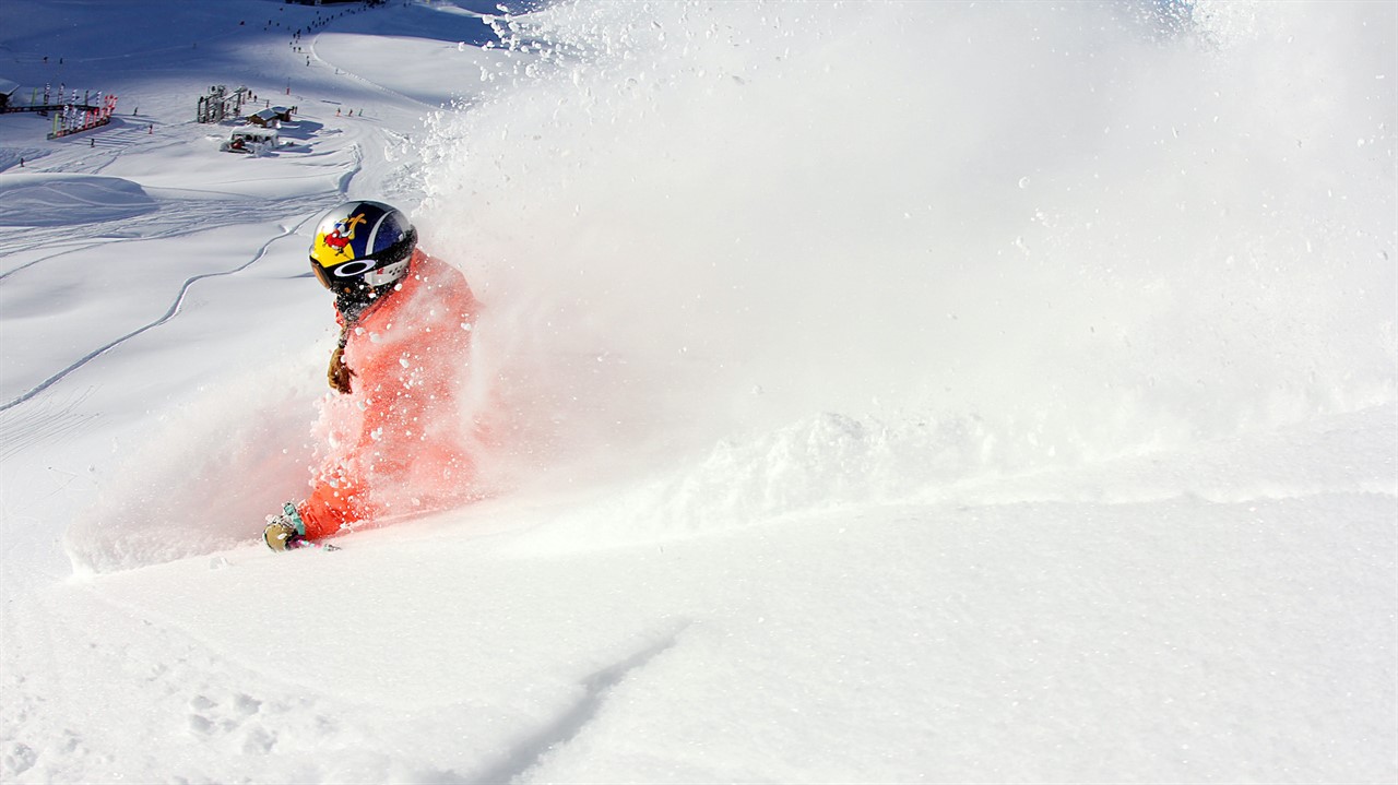 Skier skiing downhill in a cloud of snow