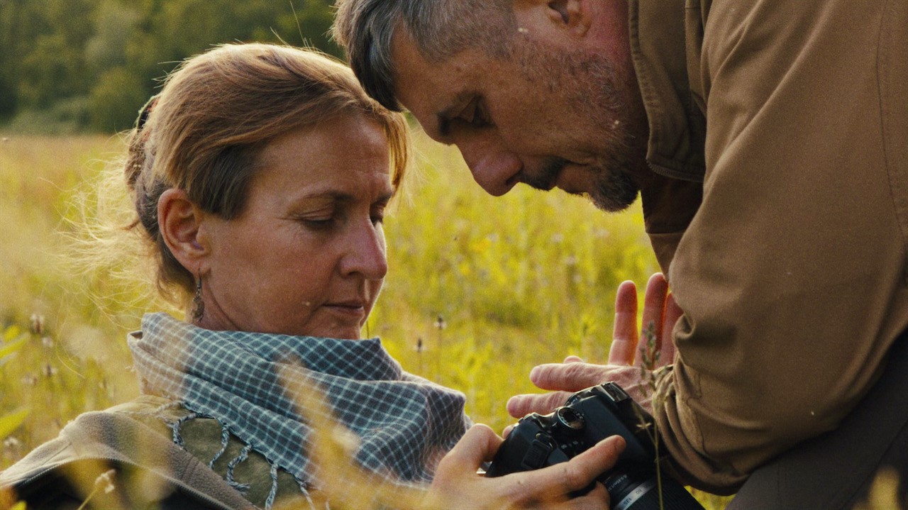 Man and woman looking at a digital camera