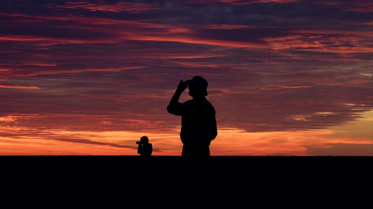 Sihouette of two people against a sunset