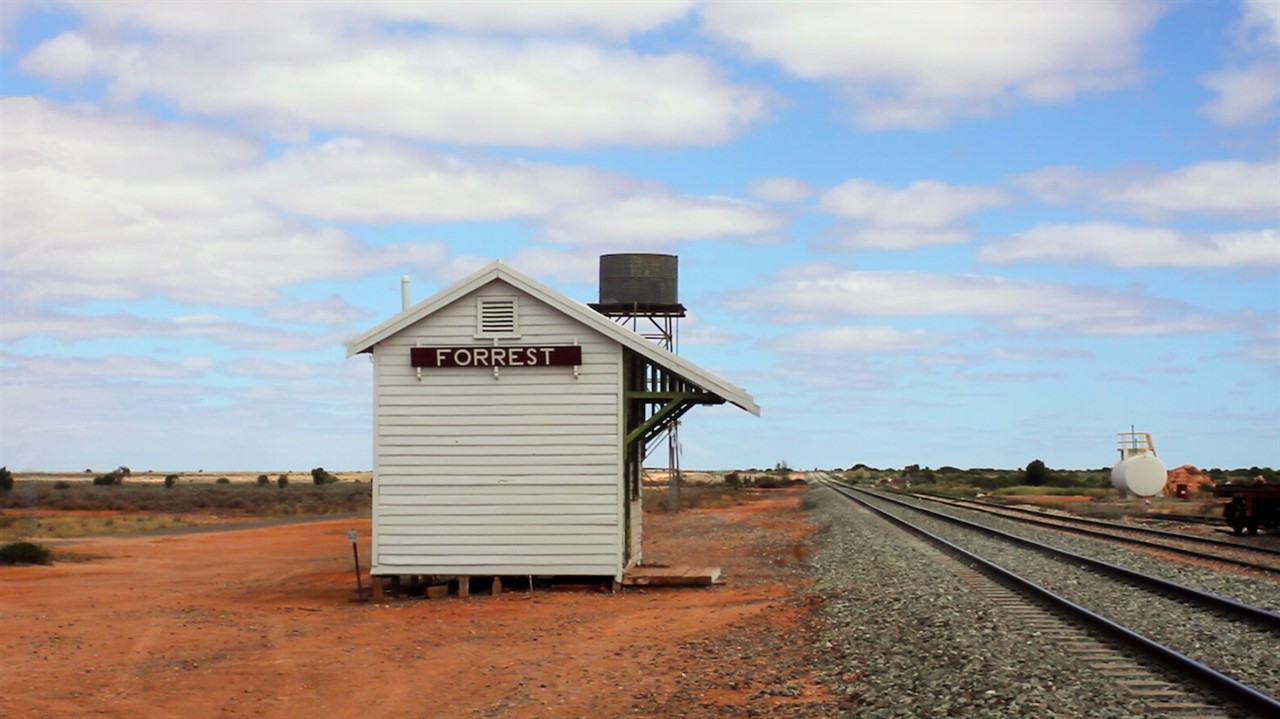 Small train station beside rail tracks