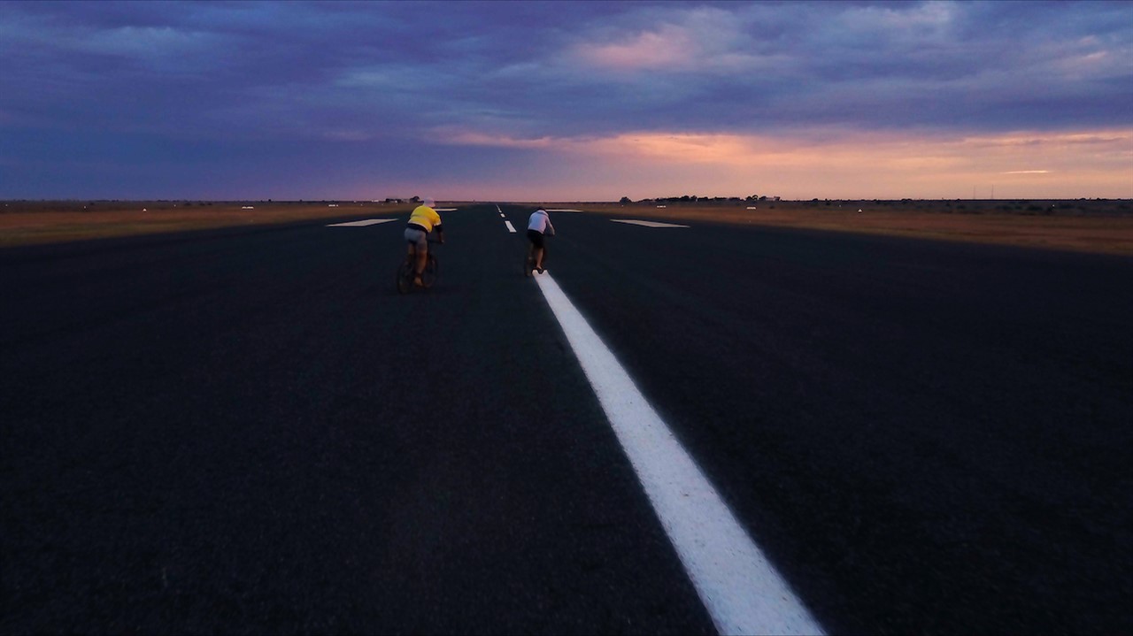 People biking down a very wide road