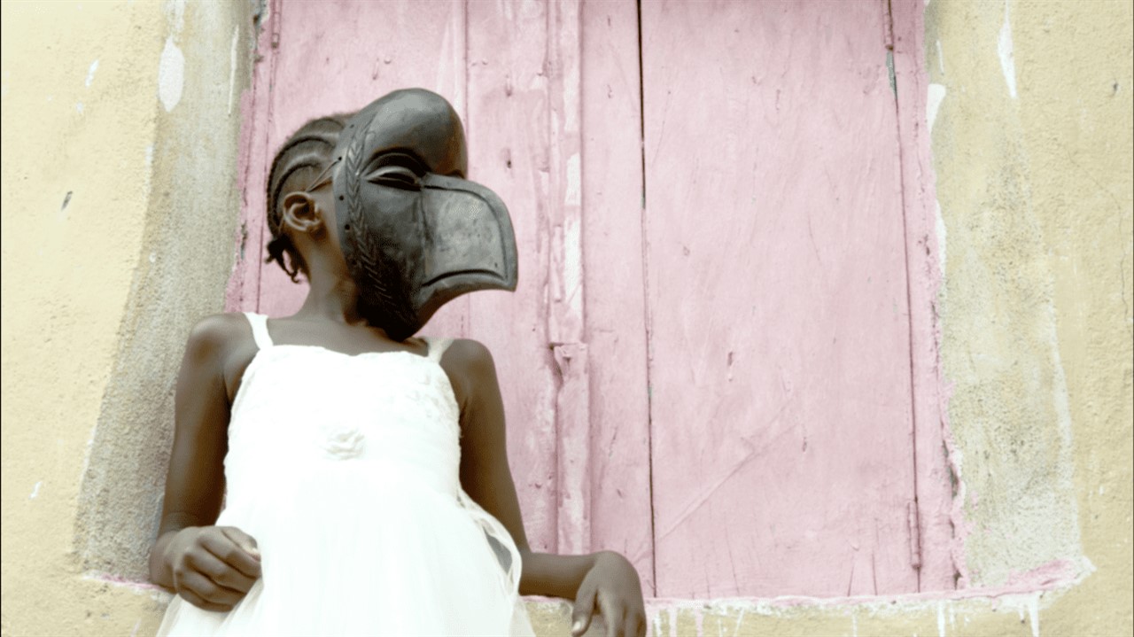 Young girl wearing a wooden bird mask