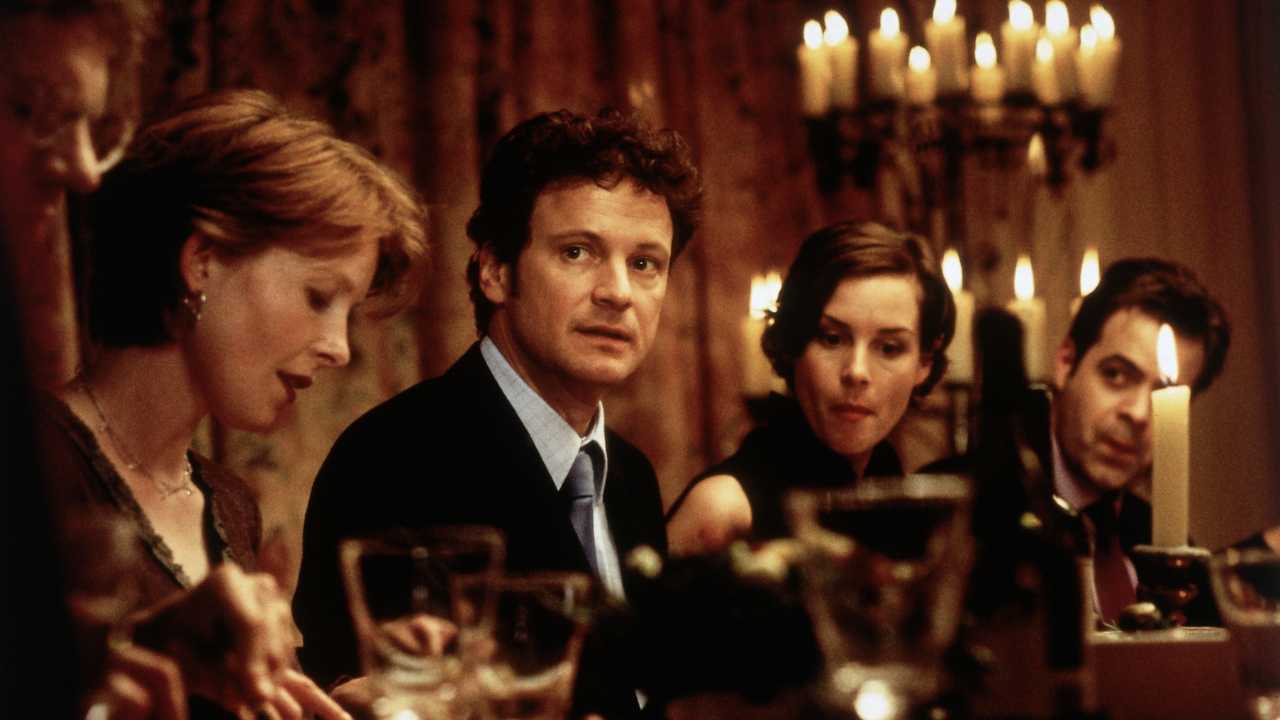 Colin Firth sitting at a dinner table