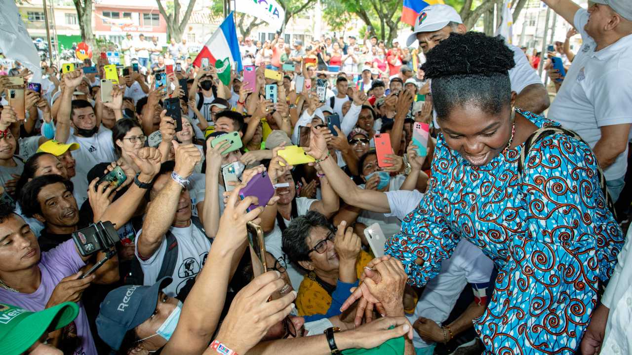 a woman being greeted by a crowd of fans