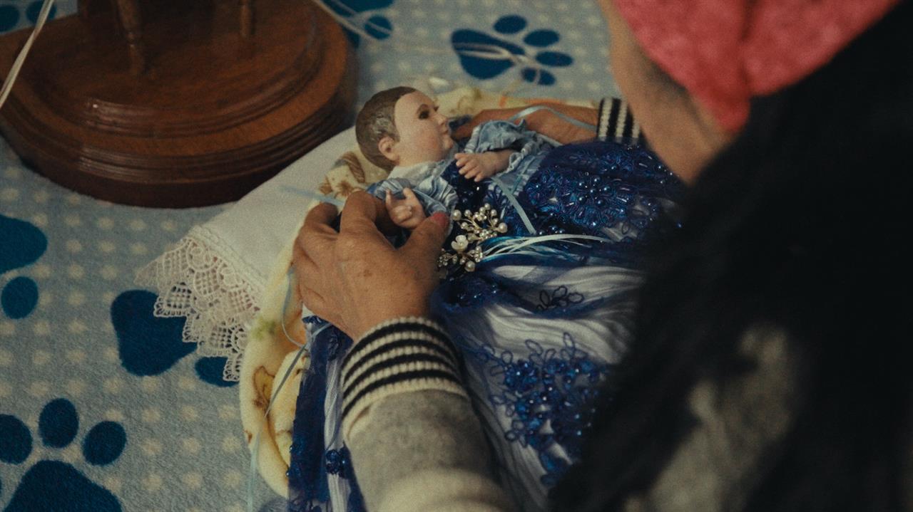 A woman dresses a Baby Jesus icon