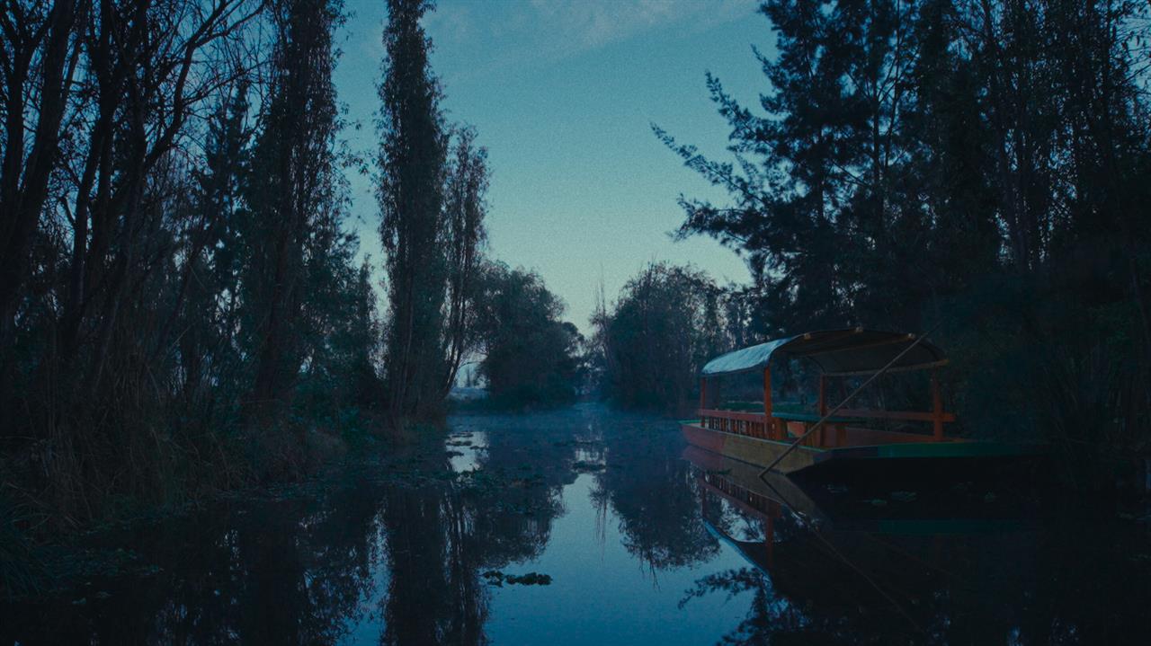 A docked gondola in a serene canal of Xochimilco