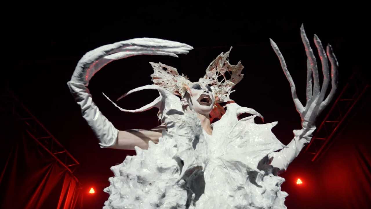 a person in elaborate makeup with long claws