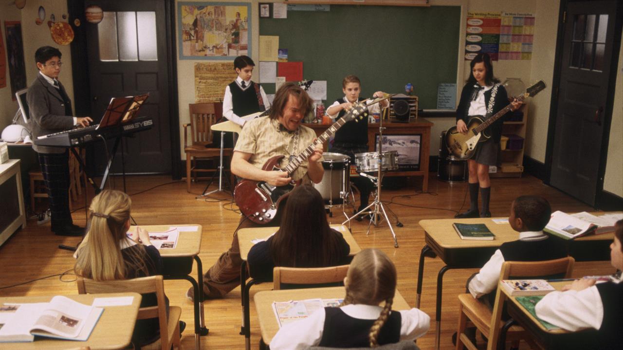 a man plays the guitar in front of a school classr